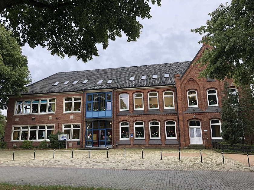 Unser roter Altbau mit den weißen Fenstern und dem blauen Eingang.