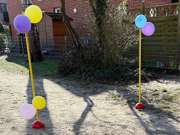 Sackhüpfen um zwei geschmückte Stangen und wieder zurück.