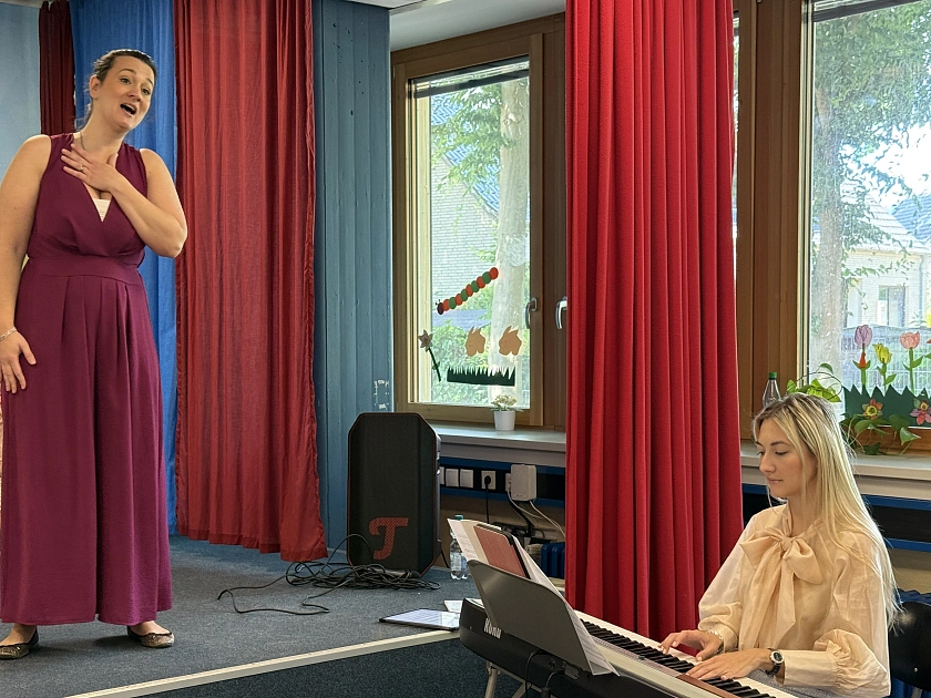 Eine Musikerin singt, die andere spielt. 