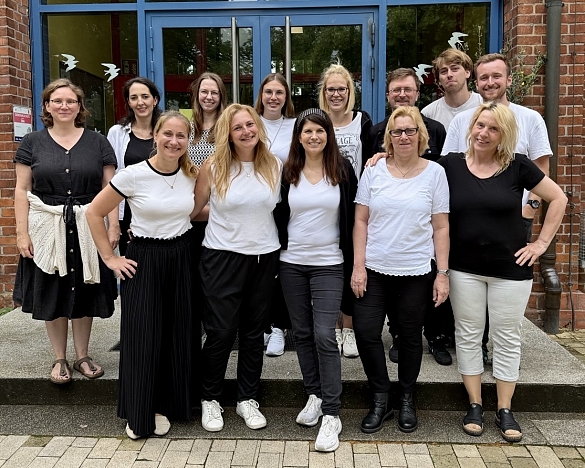 Bild vom Kollegium. Alle sind schwarz-weiß angezogen. 