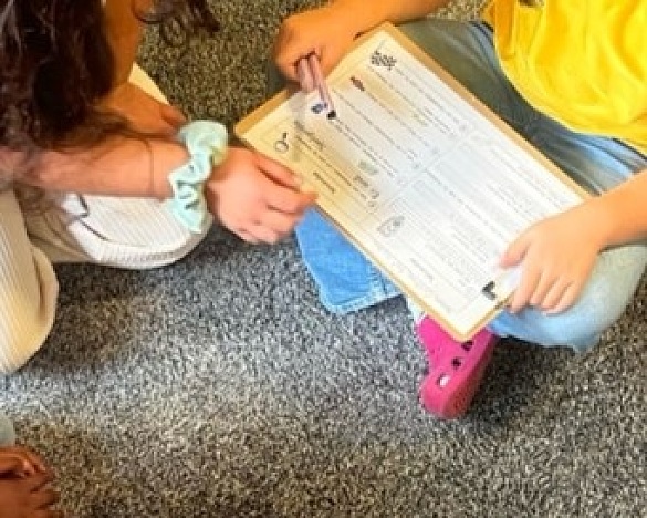 Die Kinder gehen zusammen einen Fragebogen zur Schulrallye durch. 