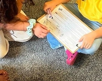Die Kinder gehen zusammen einen Fragebogen zur Schulrallye durch. 